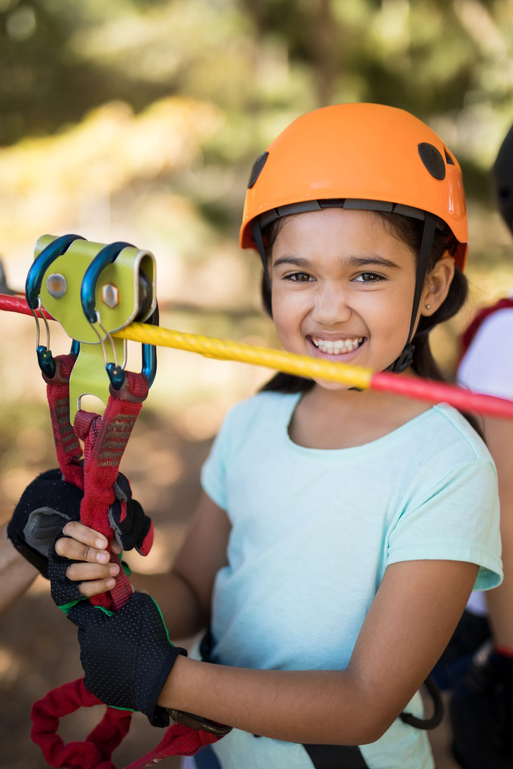 Cute girl enjoying zip line adventure on sunny day